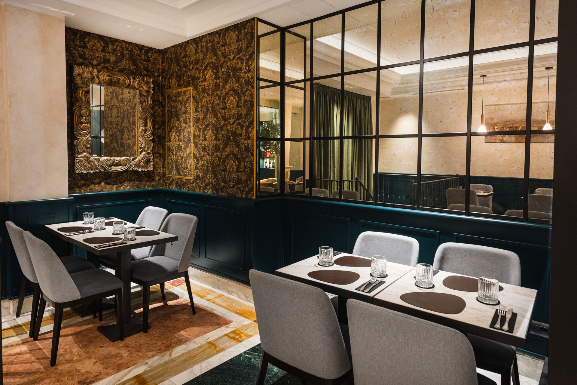La sala del Ramo Bistrot: carta da parati damascata color bronzo, specchio dorato e boiserie verde petrolio
